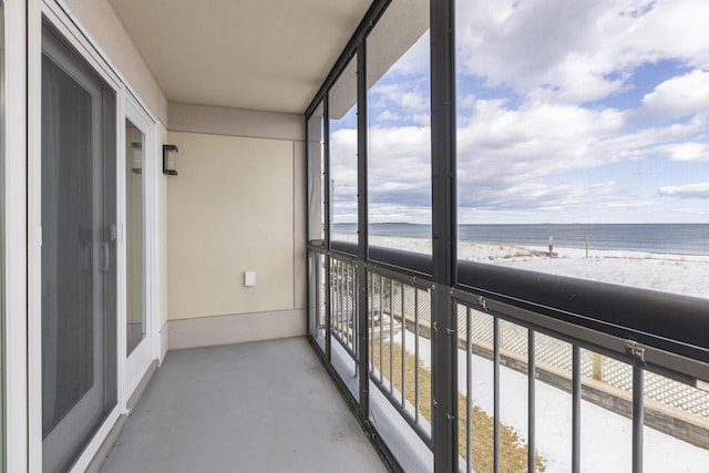 unfurnished sunroom with a water view and a beach view