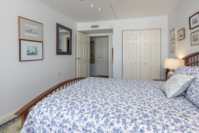 bedroom with a closet, visible vents, and baseboards