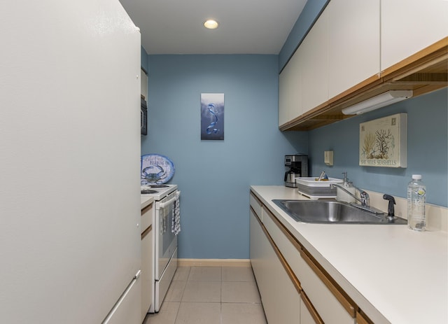 kitchen with light tile patterned floors, light countertops, white cabinetry, a sink, and white appliances