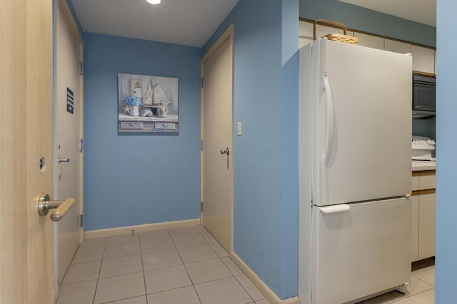 hallway with light tile patterned floors and baseboards