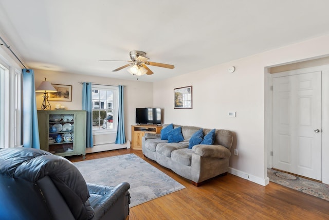 living area with a ceiling fan, wood finished floors, baseboards, and a baseboard radiator