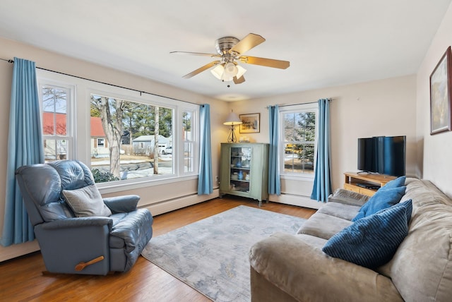 living area with a wealth of natural light, wood finished floors, and baseboard heating