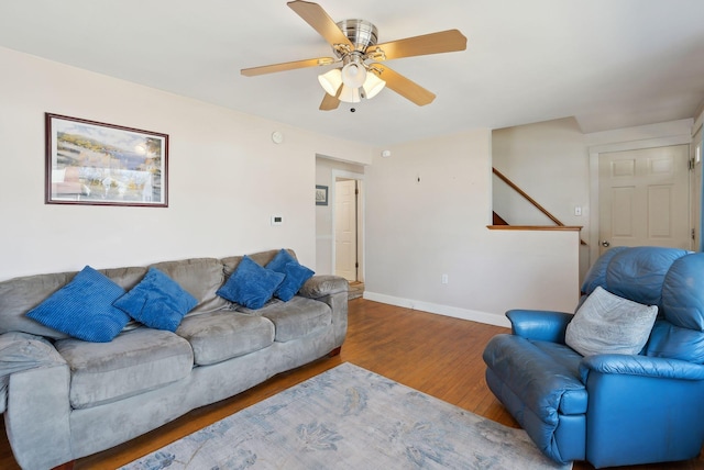 living area featuring ceiling fan, baseboards, and wood finished floors