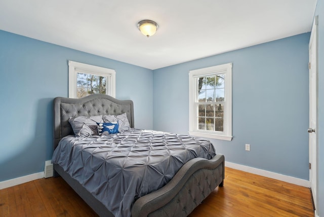 bedroom with baseboards and hardwood / wood-style flooring