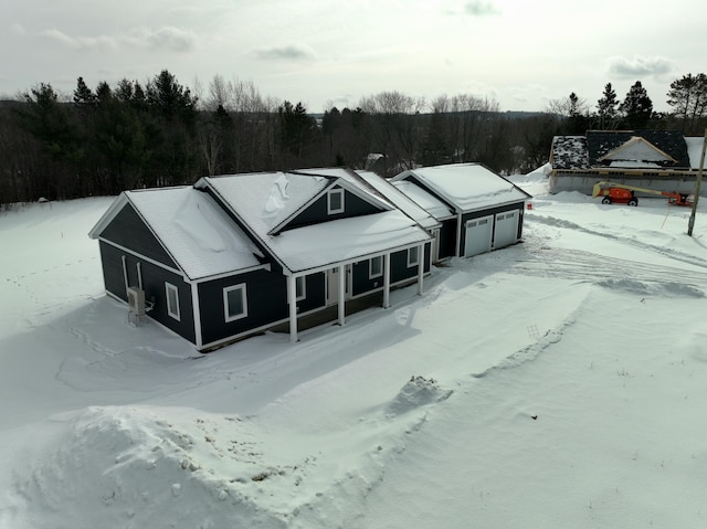 snowy aerial view featuring a forest view