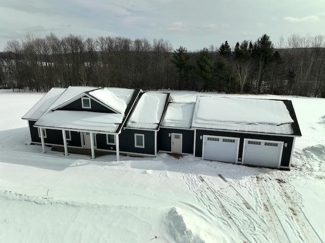 view of front of home with a garage and a view of trees