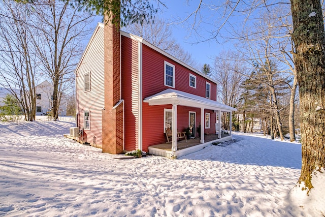 view of front of house with covered porch and a chimney