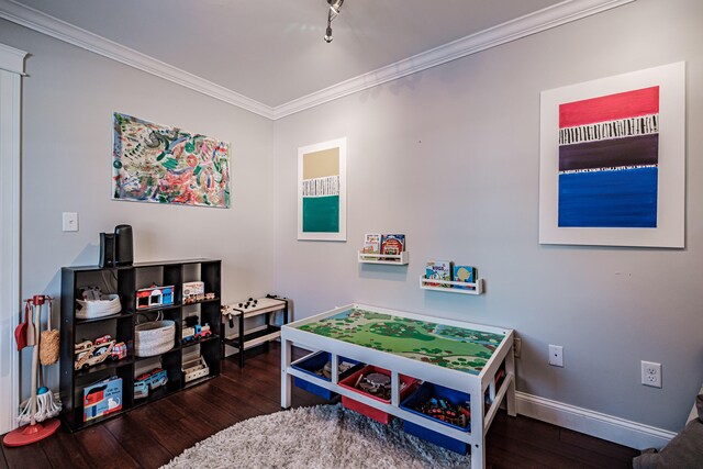 playroom with dark wood-style floors, ornamental molding, and baseboards