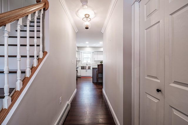 hallway featuring dark wood-style flooring, stairway, ornamental molding, a sink, and baseboards