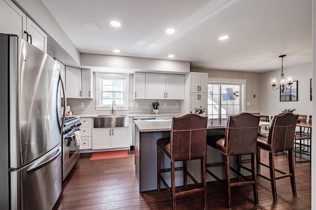 kitchen with a sink, appliances with stainless steel finishes, white cabinets, and light countertops