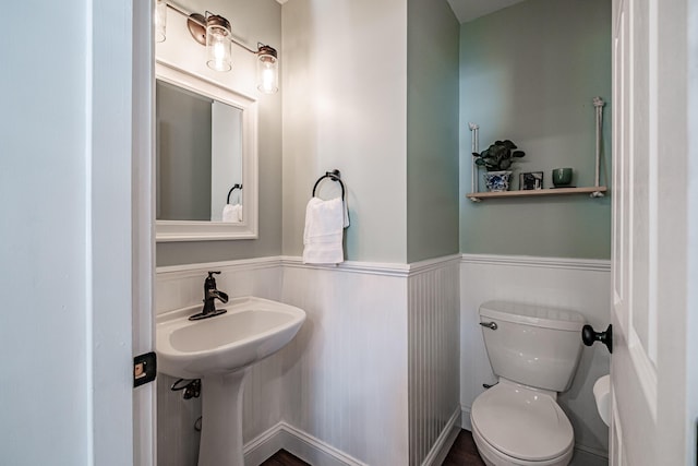 bathroom featuring wainscoting and toilet