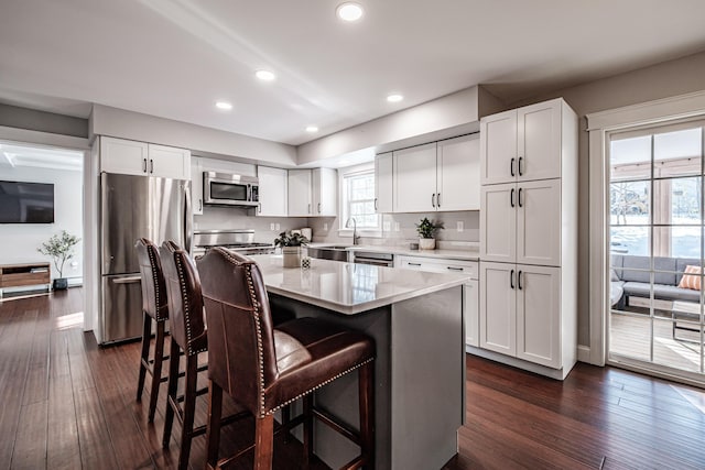 kitchen with light countertops, appliances with stainless steel finishes, a center island, and white cabinets