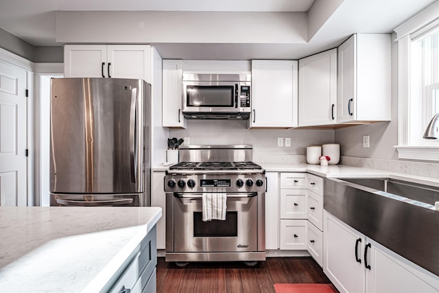 kitchen featuring appliances with stainless steel finishes, dark wood-style flooring, and white cabinets