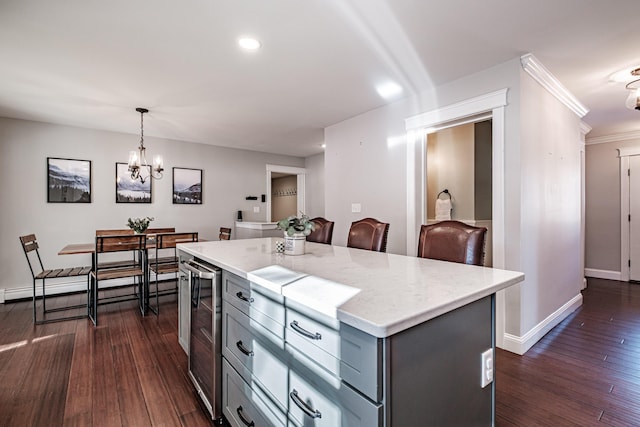 kitchen with gray cabinetry, baseboards, a center island, dark wood-style floors, and pendant lighting