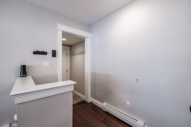 hallway featuring a baseboard radiator, baseboards, and dark wood-type flooring