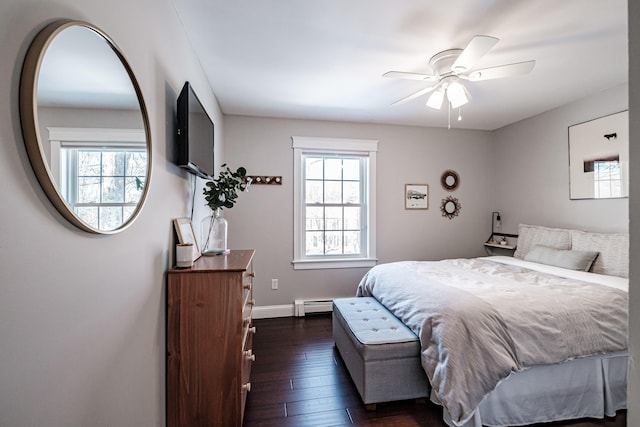 bedroom featuring baseboards, multiple windows, baseboard heating, and dark wood-style flooring