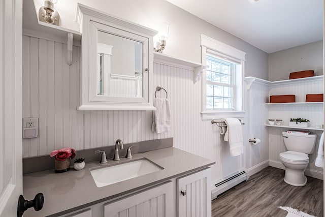 bathroom with a baseboard radiator, vanity, toilet, and wood finished floors