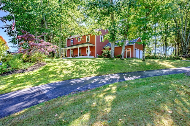 view of front of home featuring covered porch, driveway, and a front lawn