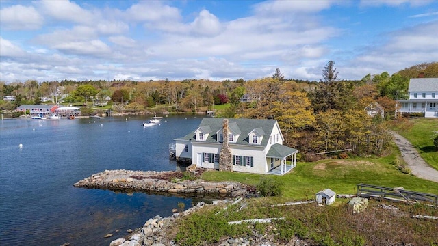 view from above of property with a large body of water and a heavily wooded area