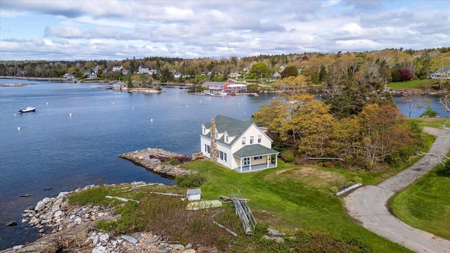 view from above of property with a nearby body of water and a heavily wooded area