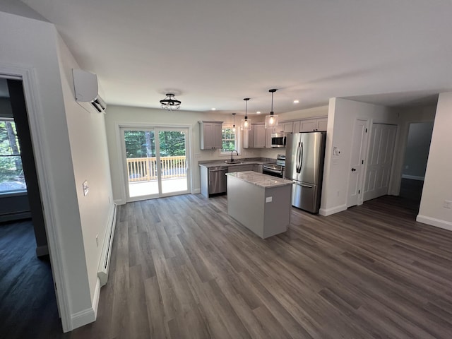 kitchen featuring baseboards, a sink, appliances with stainless steel finishes, a baseboard heating unit, and a center island