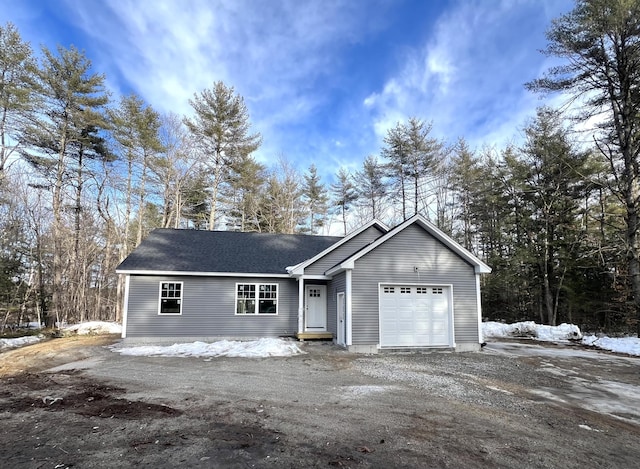 view of front of house with a garage, driveway, and a shingled roof