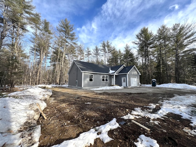 view of front of property with a view of trees and a garage