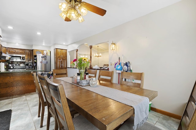 dining space featuring recessed lighting, arched walkways, ceiling fan with notable chandelier, and light tile patterned floors
