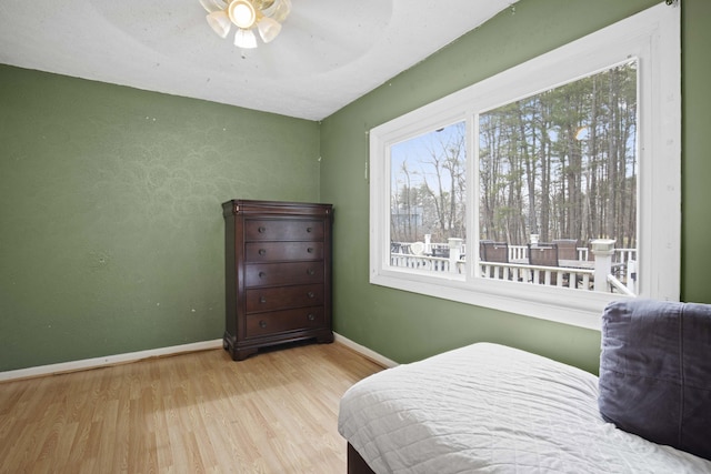 bedroom with baseboards, wood finished floors, and ceiling fan