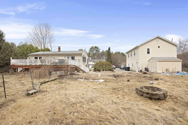 view of yard with a storage shed, a deck, an outdoor fire pit, and an outdoor structure