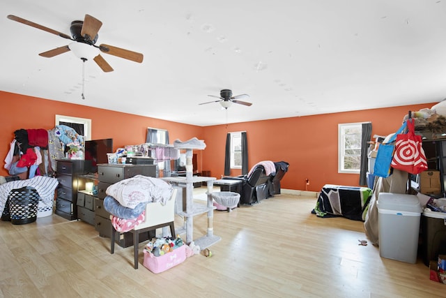 living area with a ceiling fan and wood finished floors