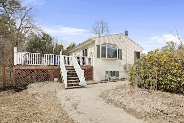 back of house featuring stairs and a wooden deck