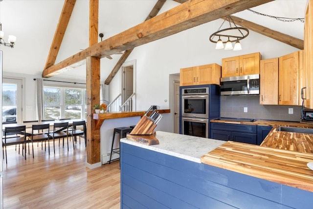 kitchen featuring beam ceiling, a baseboard heating unit, backsplash, light wood-style floors, and appliances with stainless steel finishes