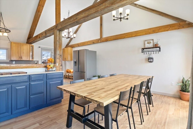 kitchen with blue cabinets, stainless steel fridge, beam ceiling, and a chandelier