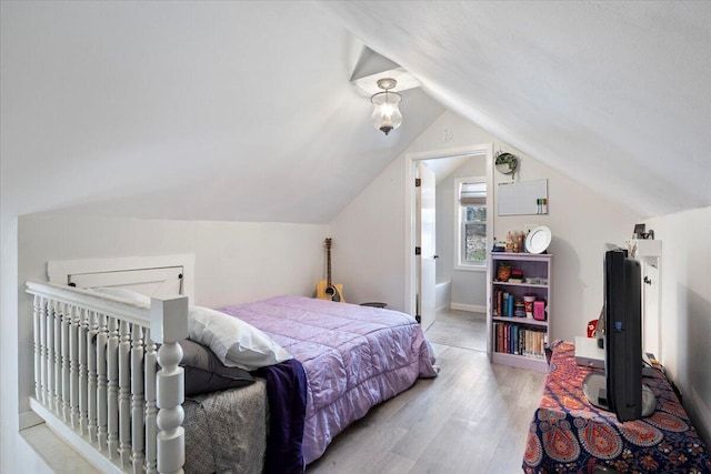 bedroom with lofted ceiling and wood finished floors