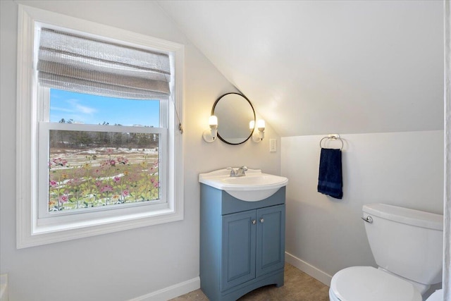 bathroom featuring baseboards, toilet, vanity, and lofted ceiling