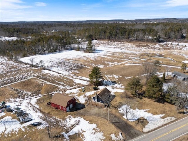 snowy aerial view featuring a forest view