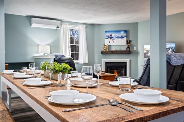 dining room with an AC wall unit and a glass covered fireplace