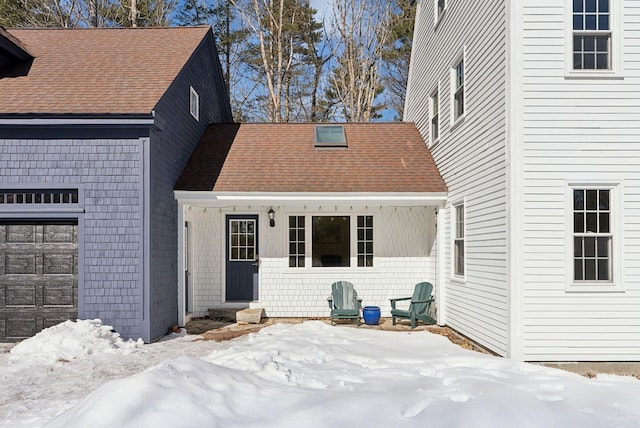 snow covered house featuring a shingled roof