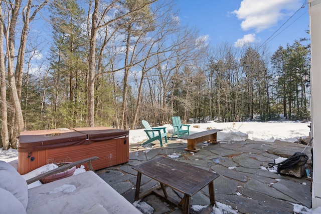 exterior space featuring a forest view and a hot tub