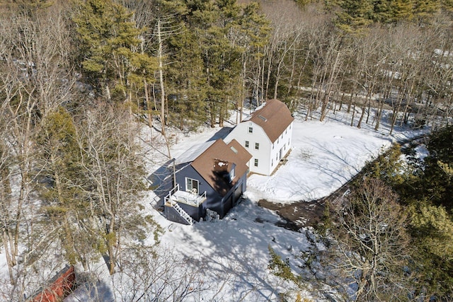 snowy aerial view with a wooded view