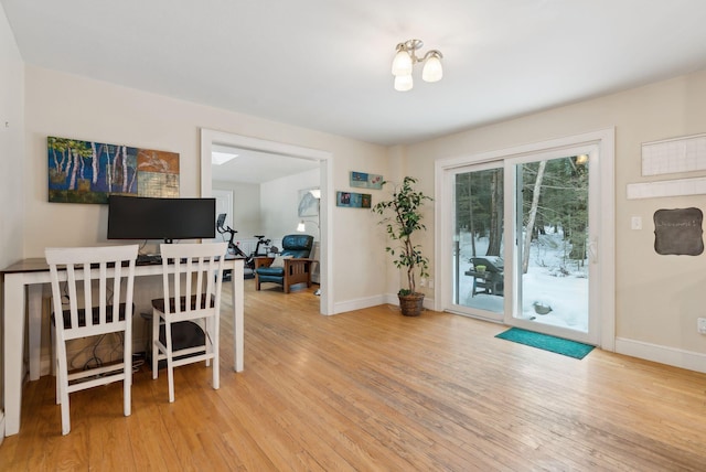 dining space featuring light wood-style flooring and baseboards