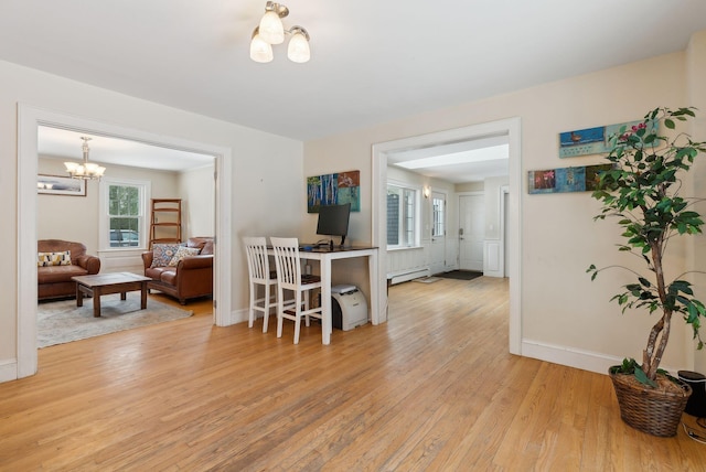 dining area with light wood-type flooring, a notable chandelier, baseboards, and a baseboard radiator