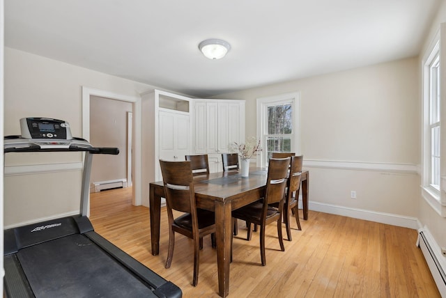 dining area with light wood-type flooring, baseboards, and baseboard heating