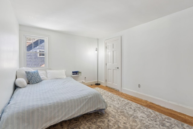 bedroom with baseboards and wood finished floors