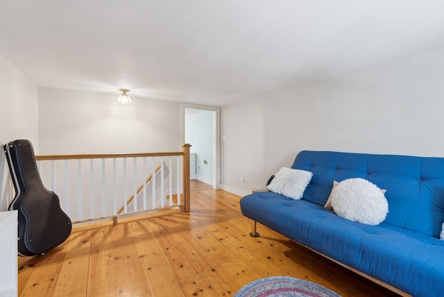 living area featuring baseboards, an upstairs landing, and hardwood / wood-style flooring