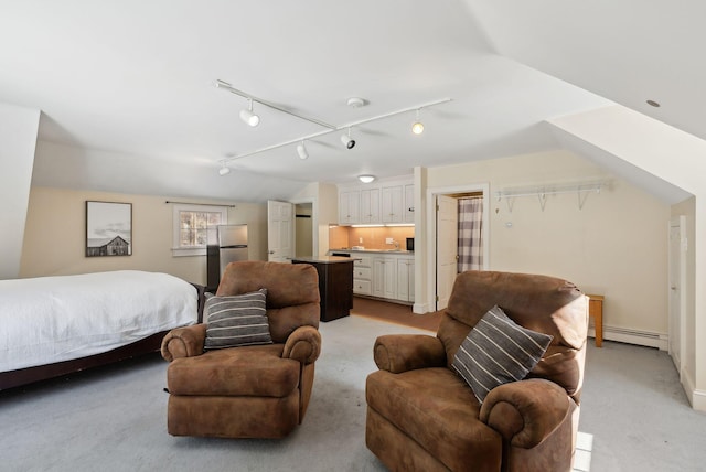 bedroom with a baseboard radiator, light colored carpet, vaulted ceiling, and freestanding refrigerator