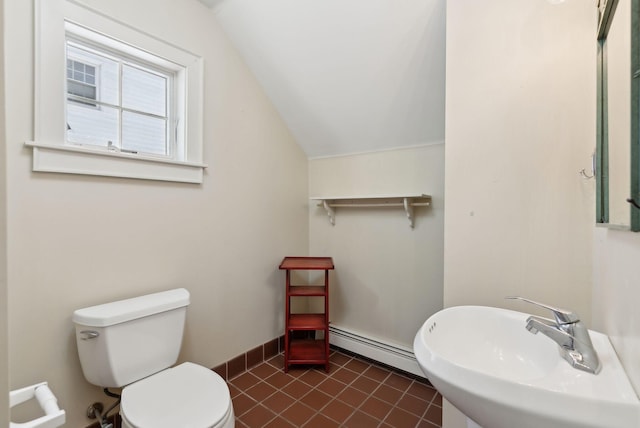 bathroom with toilet, baseboard heating, vaulted ceiling, a sink, and baseboards