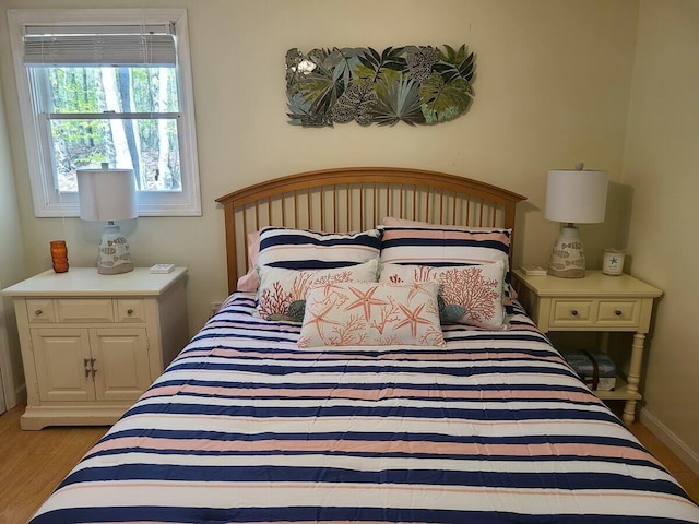 bedroom with baseboards and wood finished floors