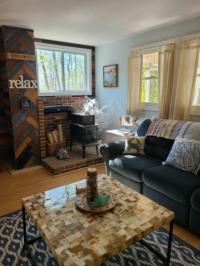 living area with a wood stove and wood finished floors